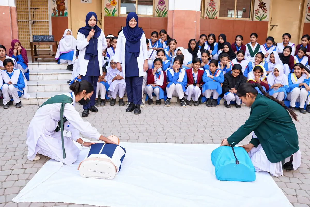 Participants practising first aid with manikins during a school outreach session